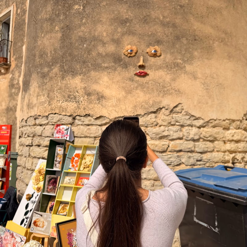 Visiteuse photographiant l’artisanat devant une tour médiévale