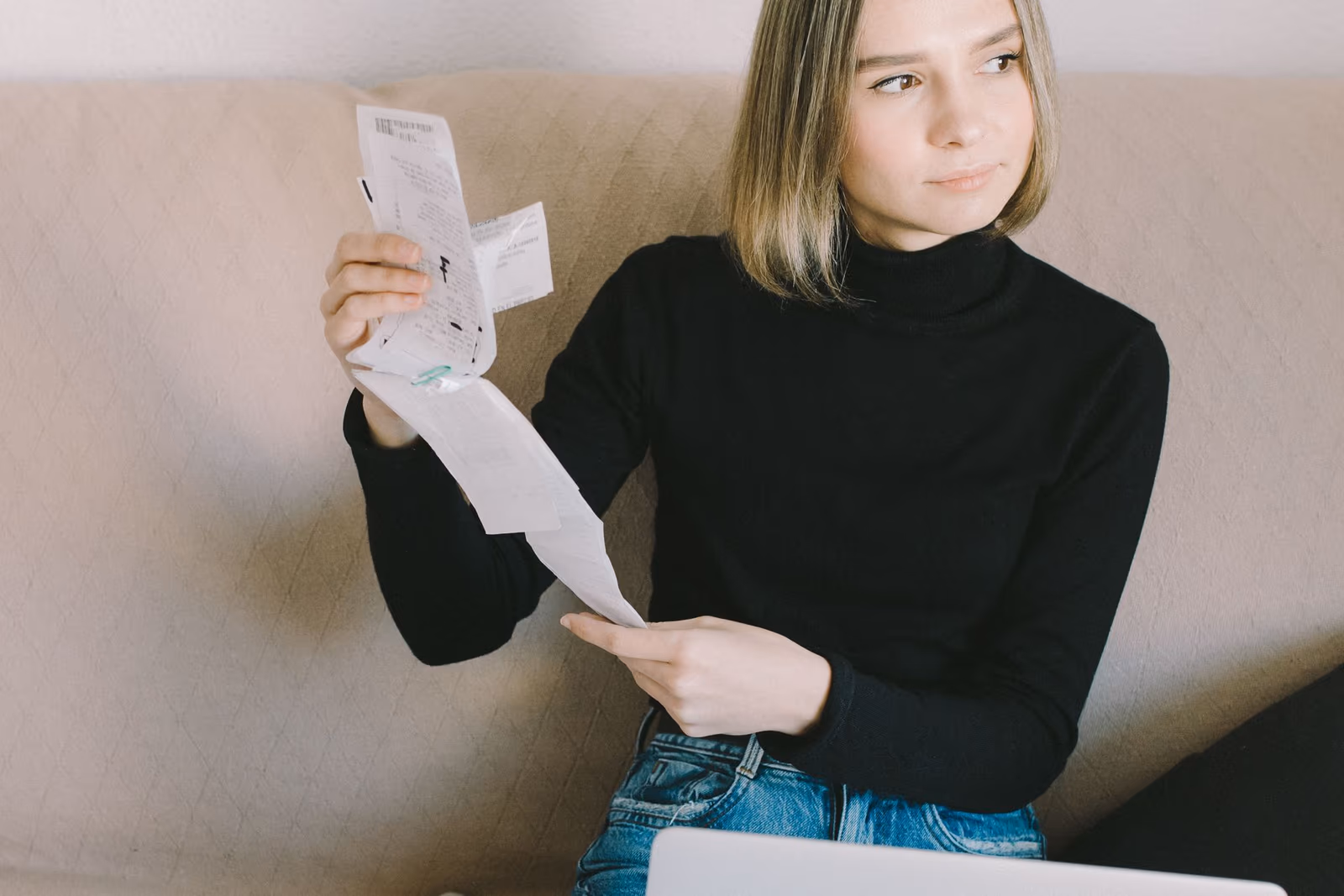 Étudiante préparant son dossier de location avec justificatifs papier et ordinateur portable