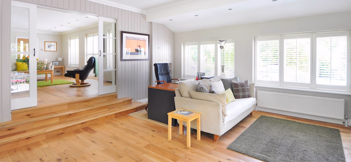Salon lumineux avec parquet et canapé beige, exemple de home staging réussi