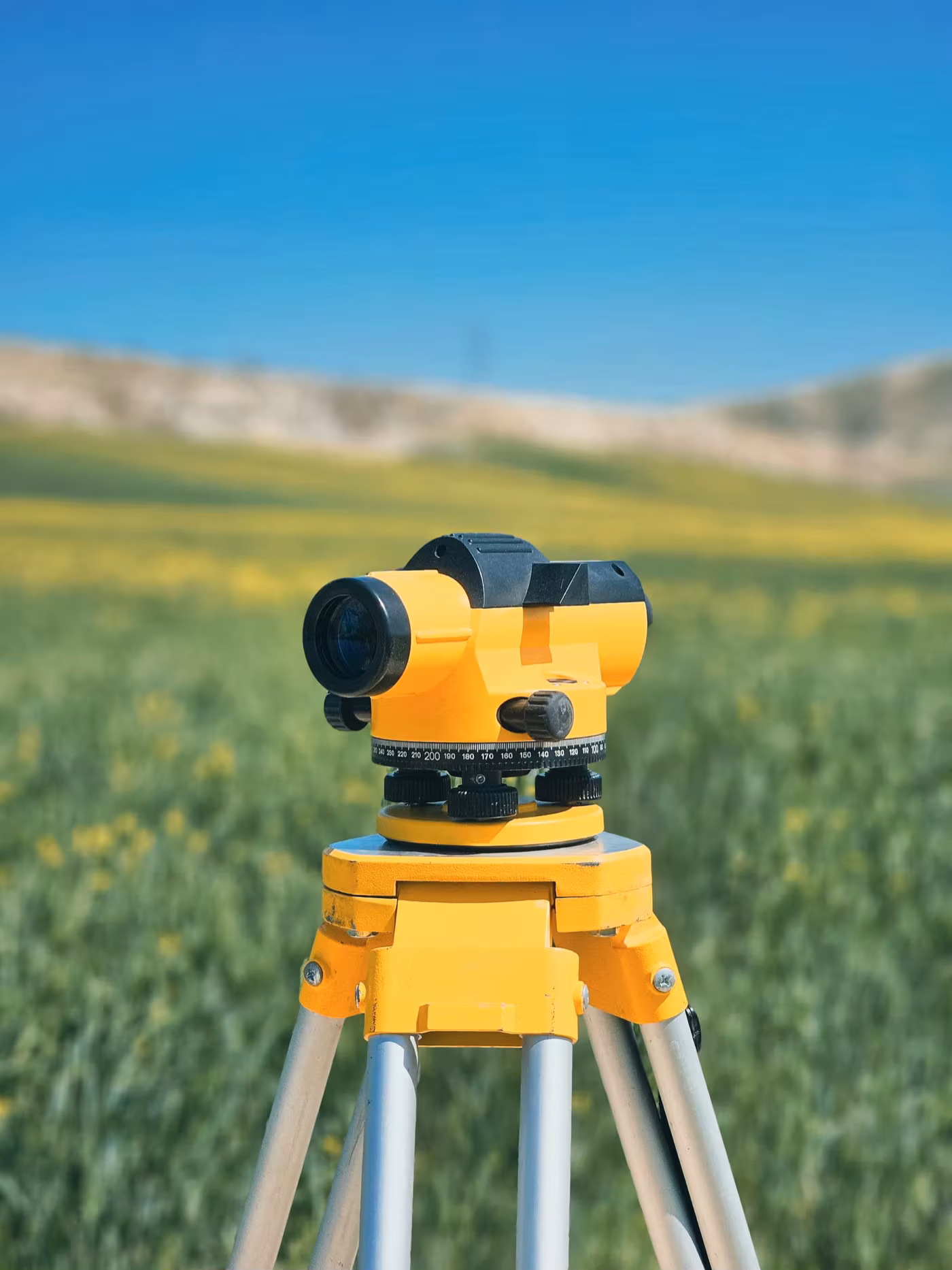 Niveau optique de géomètre sur trépied lors d'un bornage de terrain