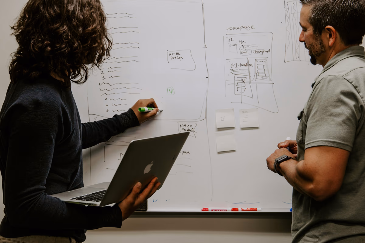 Discussion en équipe avec tableau blanc et post-its pour préparer un dossier de location étudiant