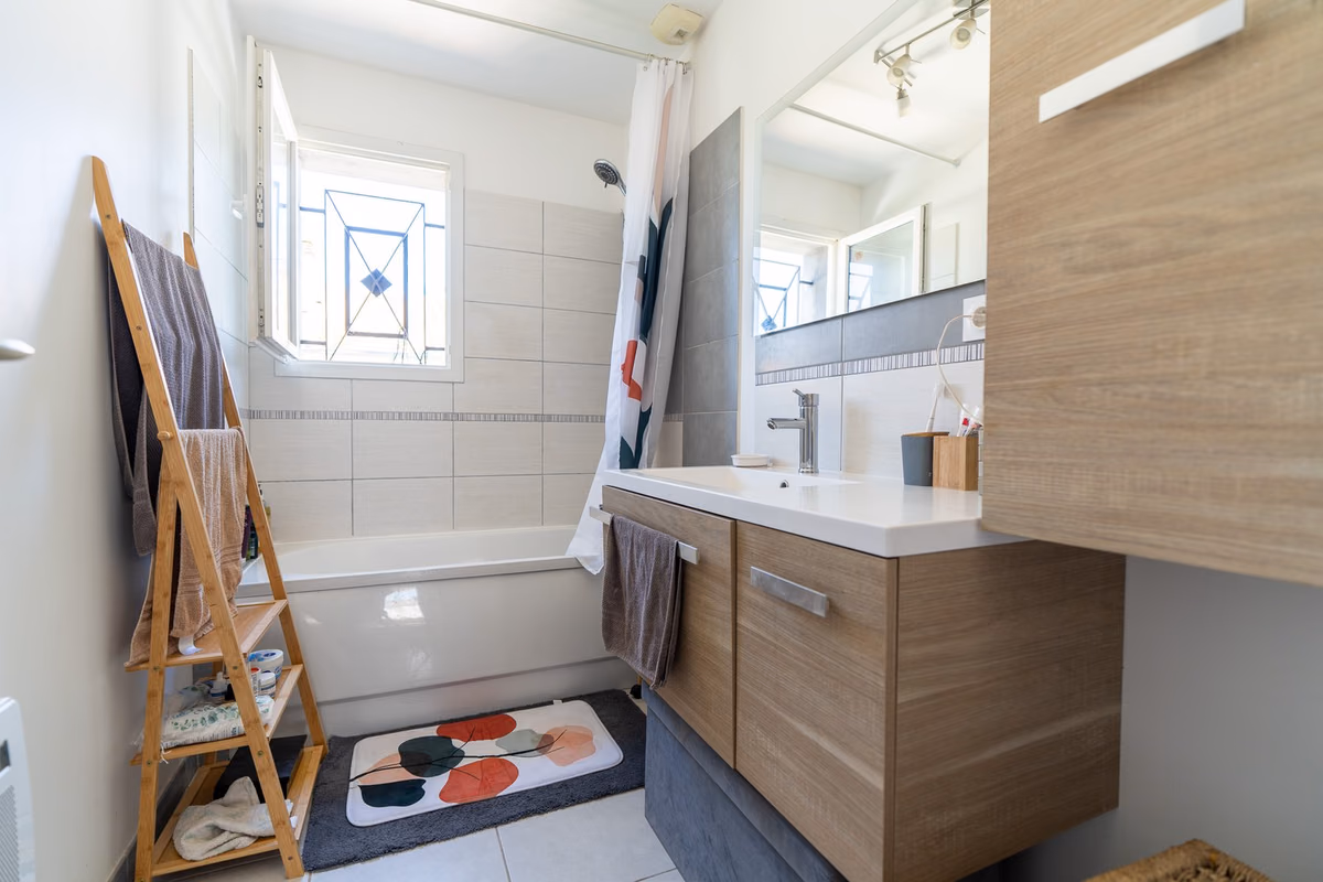 Salle de bains avec baignoire et meuble vasque, maison à vendre à Lunel-Viel
