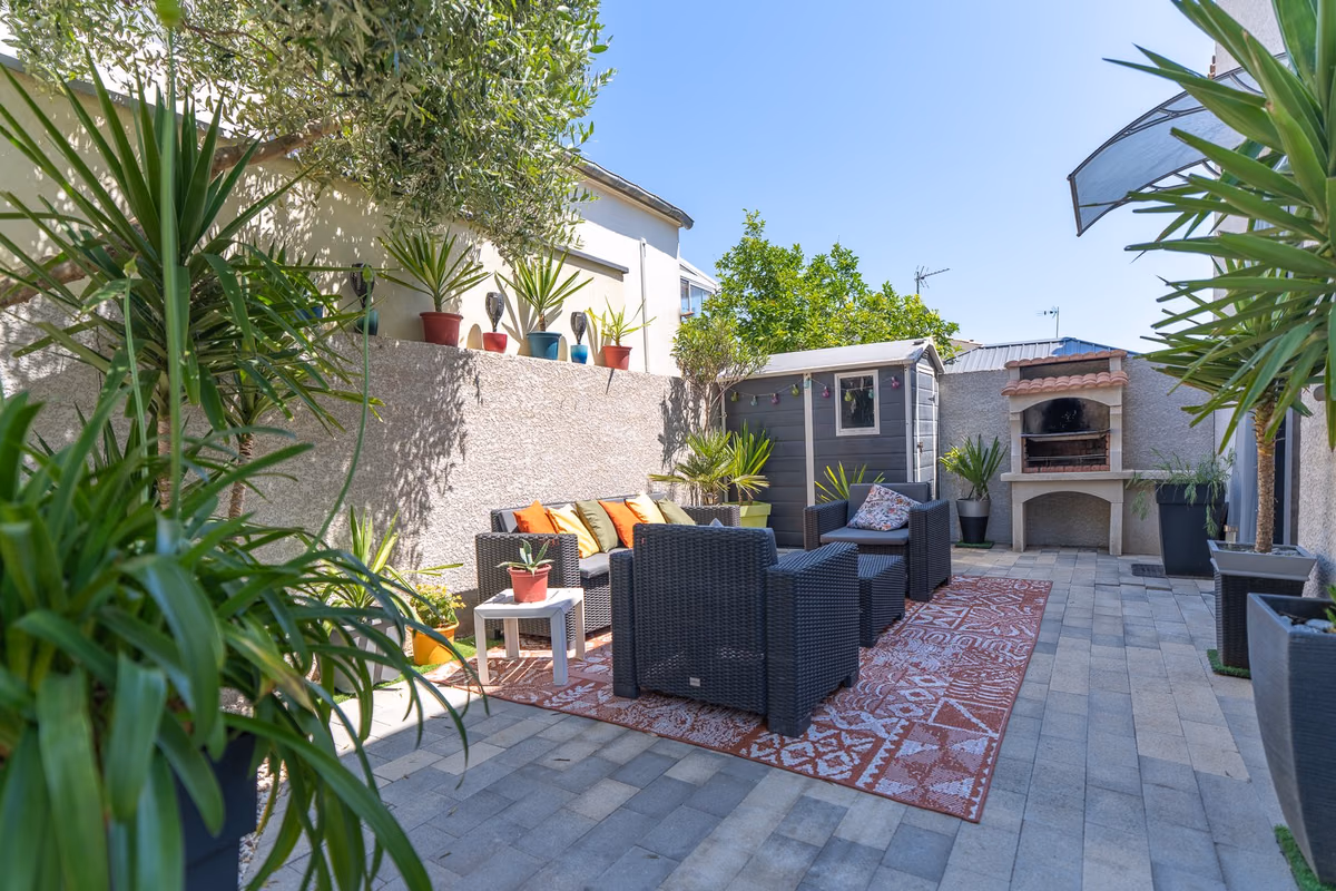 Terrasse aménagée avec salon de jardin et barbecue maçonné, maison à vendre à Lunel-Viel