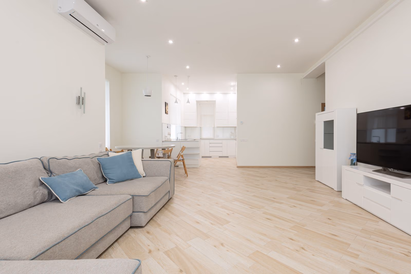 Appartement meublé lumineux avec canapé, table et cuisine ouverte