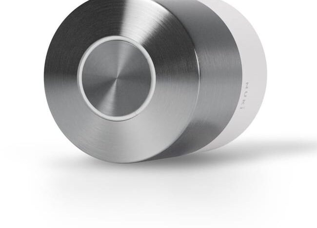 Dispositif cylindrique métal brossé avec bouton circulaire central et partie blanche.