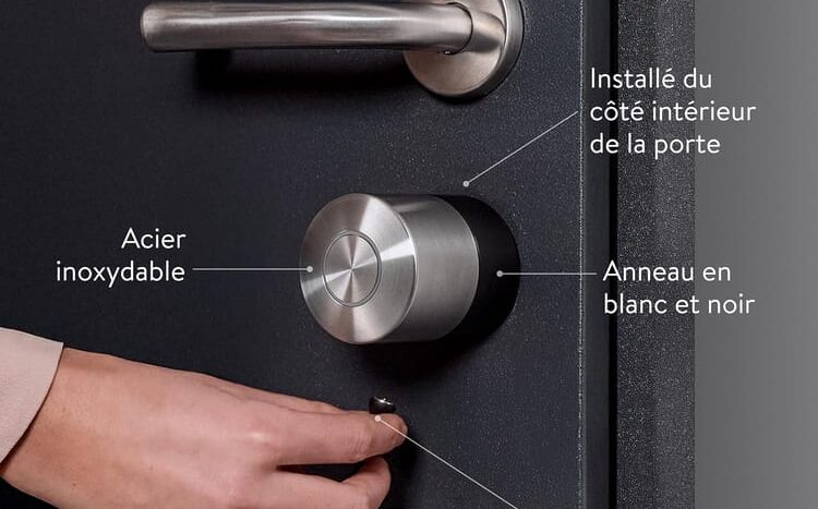 Poignée en acier inoxydable avec cylindre rond et câble de recharge magnétique sur porte noire.
